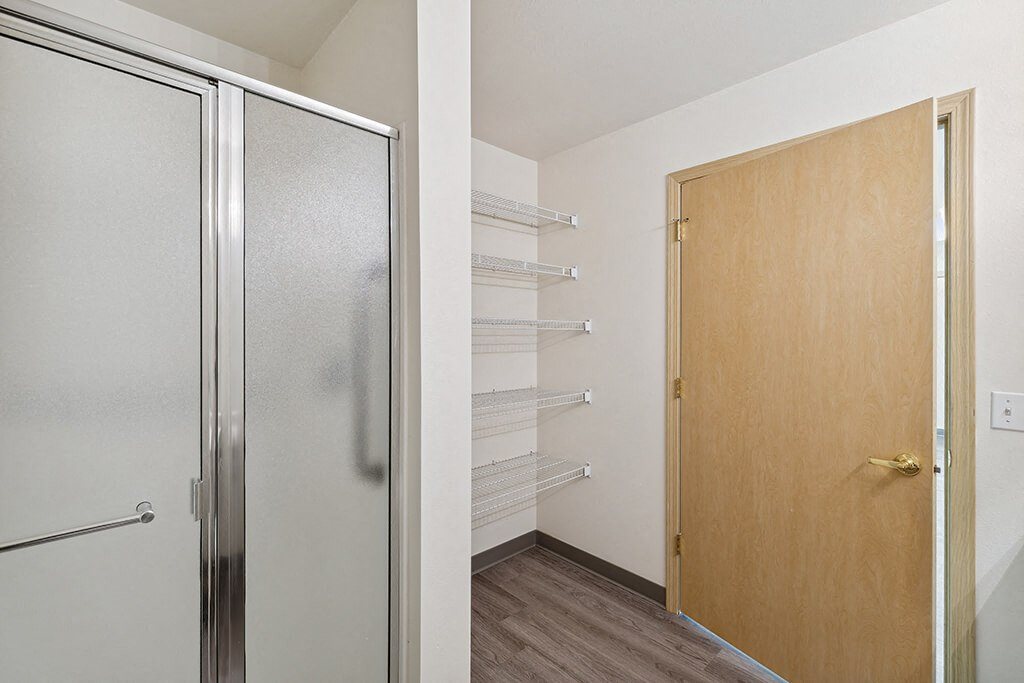 Bathroom with linen storage at Ballinger Court Senior Apartments in Edmonds WA